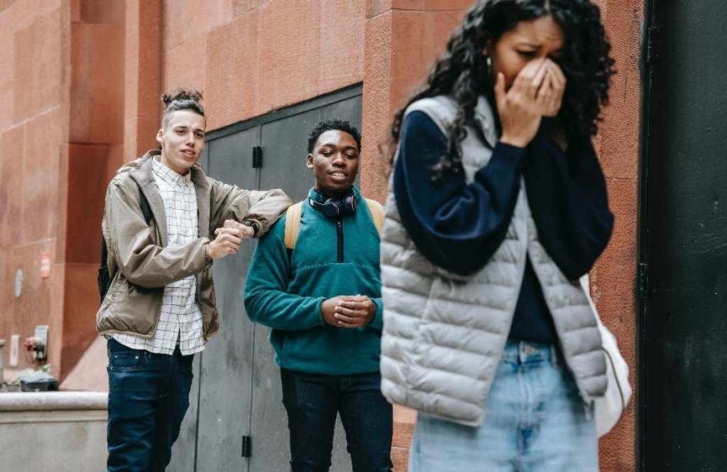 A girl crying while walking away from two men.