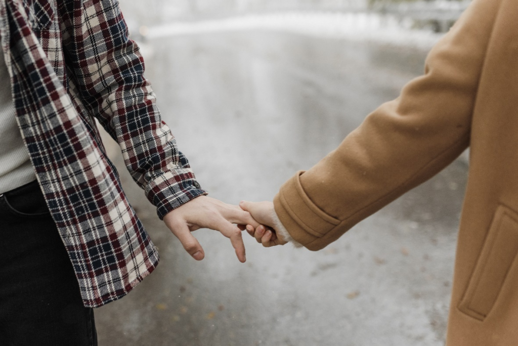 A couple holding hands with affection.